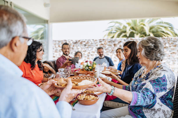 Latin multi generation family having feast on Sunday lunch stock photo
