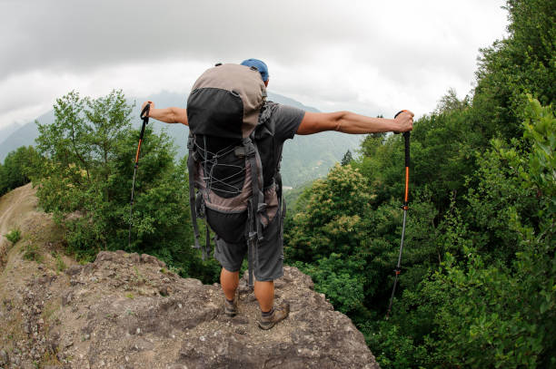 istock Male tourist with backpack stands on hill 1167976574