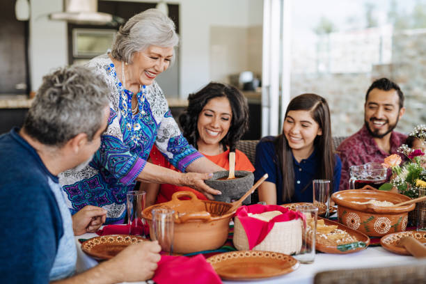 Cheerful senior Latin woman preparing lunch for her family stock photo