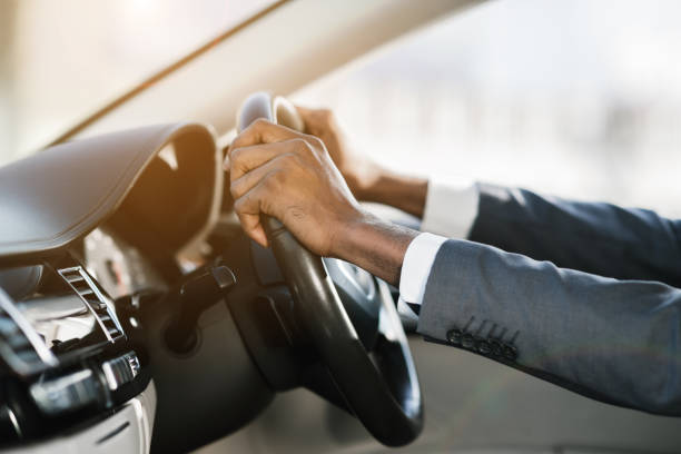 istock Afro businessman hands holding steering wheel, free space 1167978905