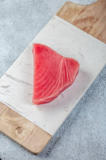 bistecca di tonno crudo su sfondo bianco cemento - tuna steak fillet food plate foto e immagini stock