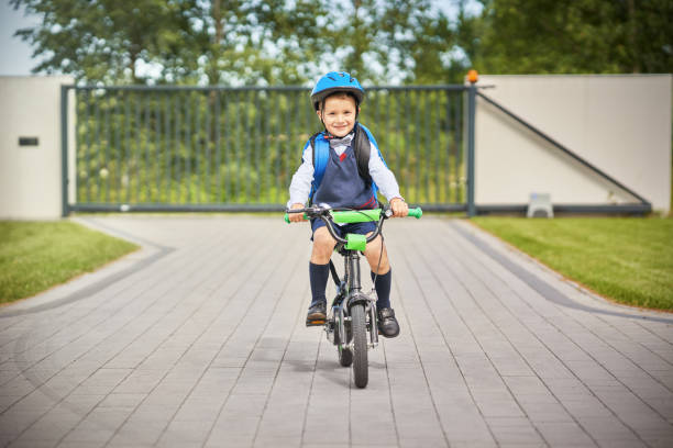 istock School boy in safety helmet riding bike with backpack 1167982496