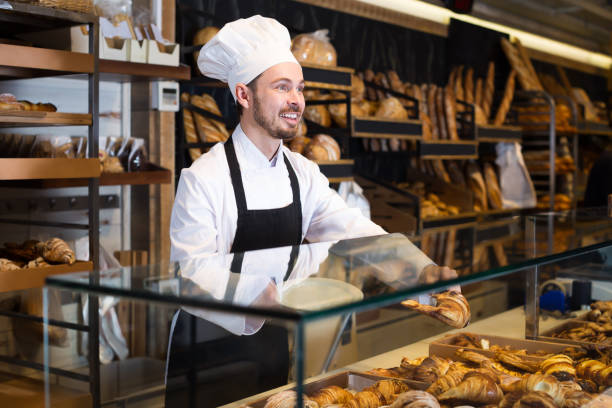 istock Good male pastry maker demonstrating croissant 1167985721