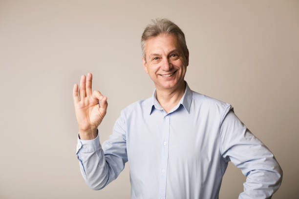 istock Mature man showing ok sign, looking at camera 1167988631