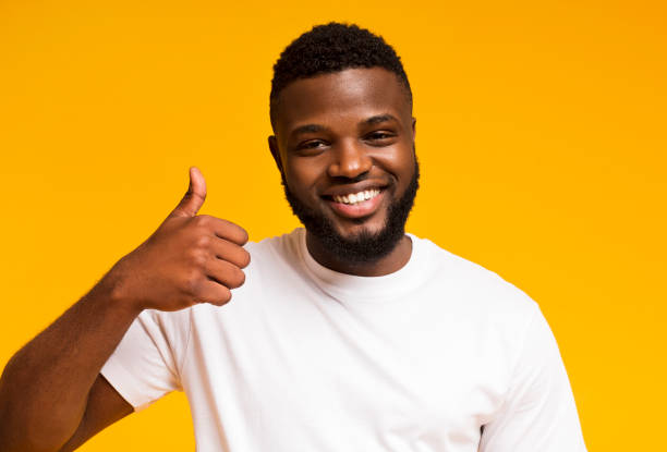 istock African american guy showing thumb up and smiling at camera 1167992468
