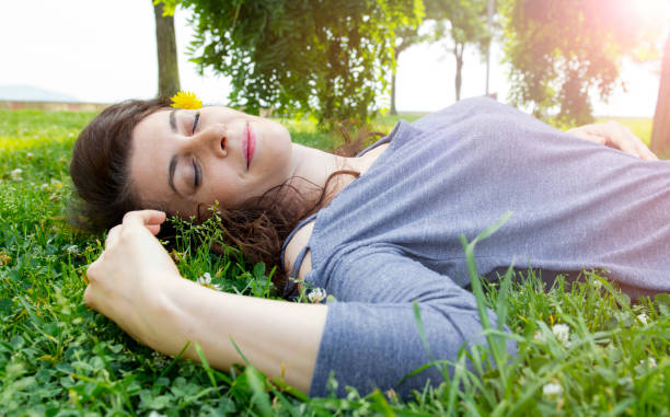 istock Young woman lying on grass 1167992541