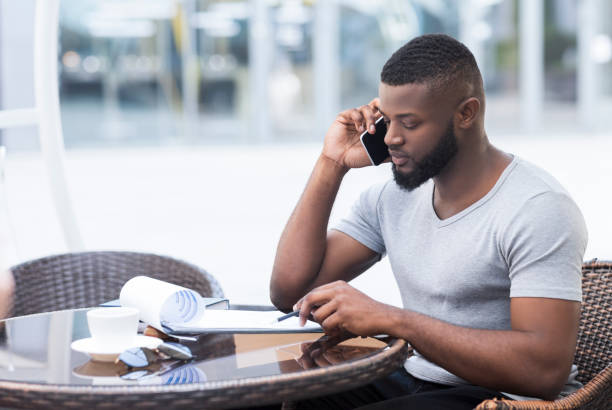 istock Serious african man checking financial plan data with collegues 1167992628