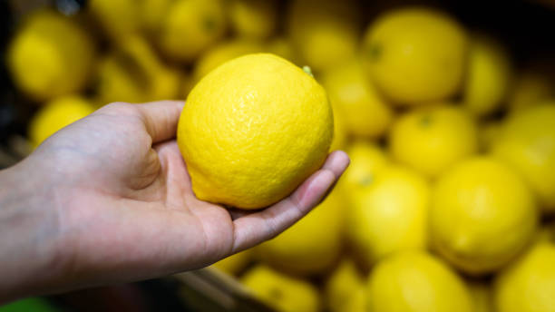 istock Female Hand pick up lemon in market 1167992696