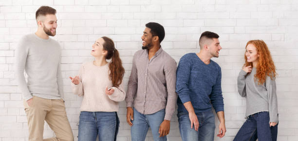 istock Diverse friends talking with each other, white wall 1167994135