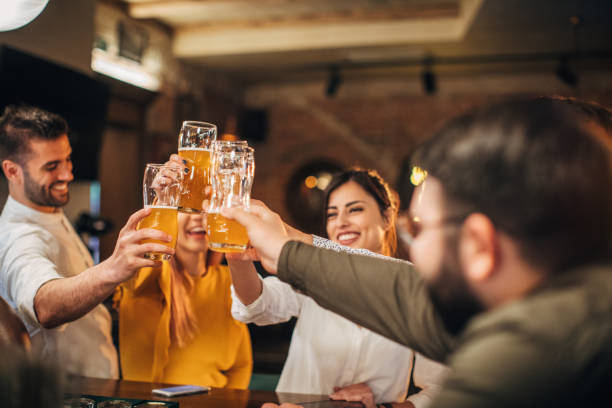 istock Group of young joyful friends having fun in a pub 1167994460
