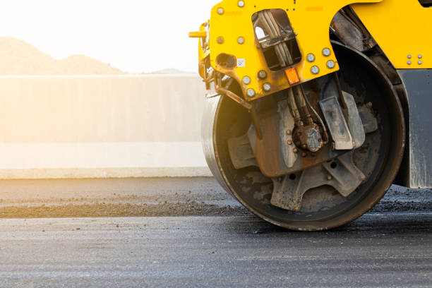 Industrial Asphalt road surface is smoothed with steel wheels, road construction machinery, asphalt paver rolling stock stock pictures, royalty-free photos & images