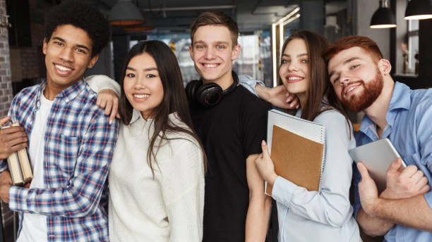 happy schoolmates posing together, smiling at camera - adult black camera caucasian imagens e fotografias de stock