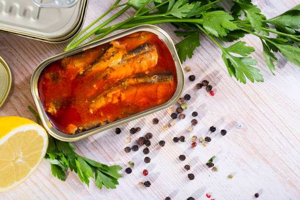 istock Tinned sardines in tomato sauce on background with greens and lemon 1168000118