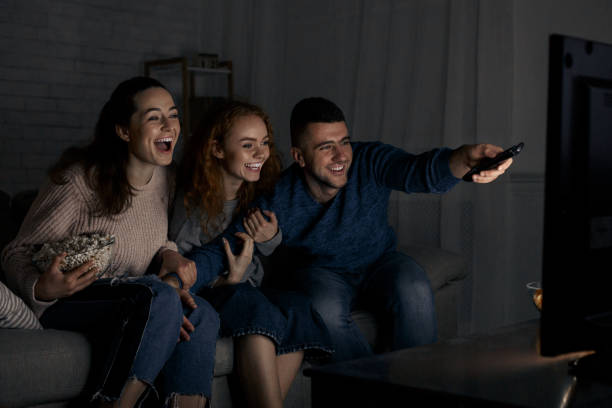 istock Excited friends watching TV and switching channels 1168000364