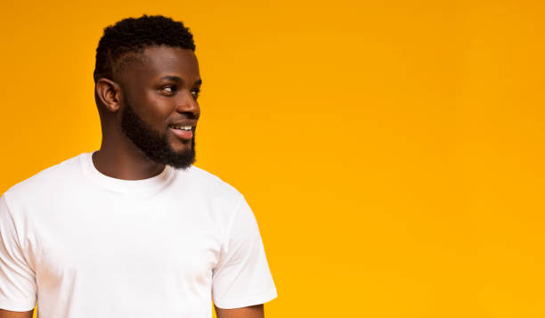 istock Half-turned smiling african american guy looking at copy space 1168000376