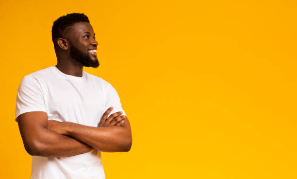 istock Pensive guy looking upwards at empty space on yellow background 1168000456
