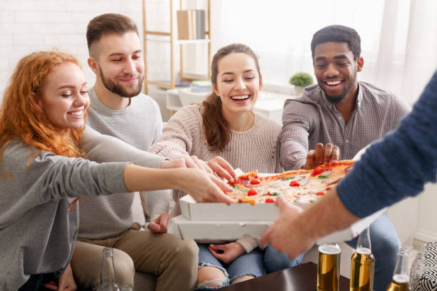 happy friends taking slices of hot pizza from box - pizza eating african descent lunch imagens e fotografias de stock