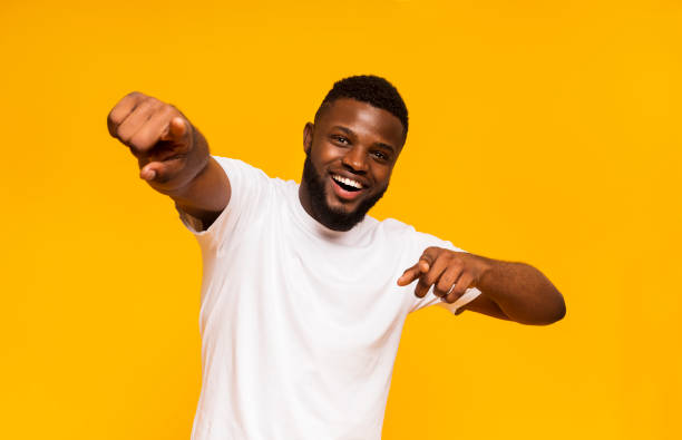 istock Cheerful african man happily indicating at camera, yellow studio background 1168001588