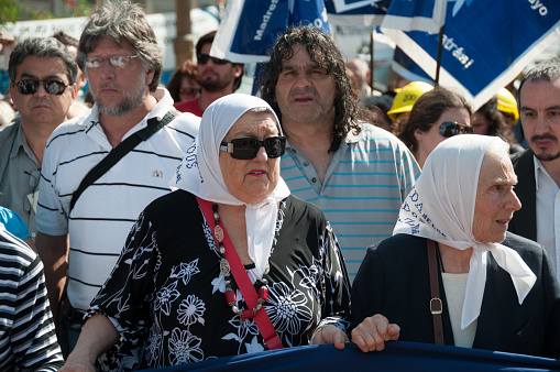 Buenos Aires, Argentina - November 18 2010: Mothers of the Plaza de Mayo walking and holding a banner on the weekly march protest.