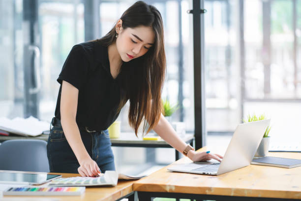 istock Young Asian graphic designer working on computor and graphics tablet in her working space 1168001696
