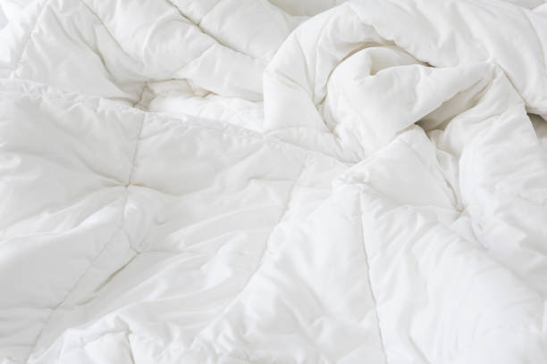 istock Close up messy white sheet and pillows on bed bedroom interior 1168001710