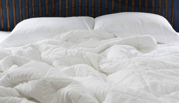 istock Comfortable of white bedding sheets and pillows with blue wall background,room interior 1168001735