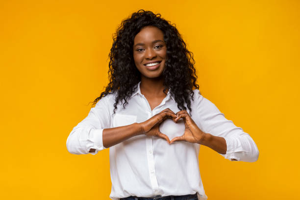 istock Cheerful afro woman shaping hands as heart on camera 1168002753