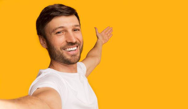 istock Smiling Young Man Taking Selfie And Showing At Copy Space 1168003102