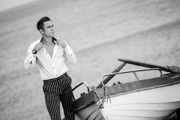 Alluring trendy male standing by boat