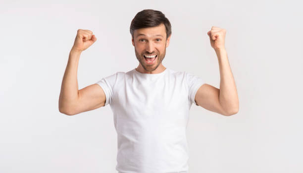 istock Joyful Man Shaking Fists Rejoicing Victory On White Studio Background 1168003186