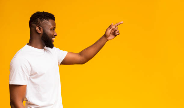 istock Smiling black man pointing and looking to copy space 1168003288