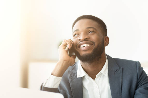 istock Happy young African man talking on phone and expressing positivity 1168003336
