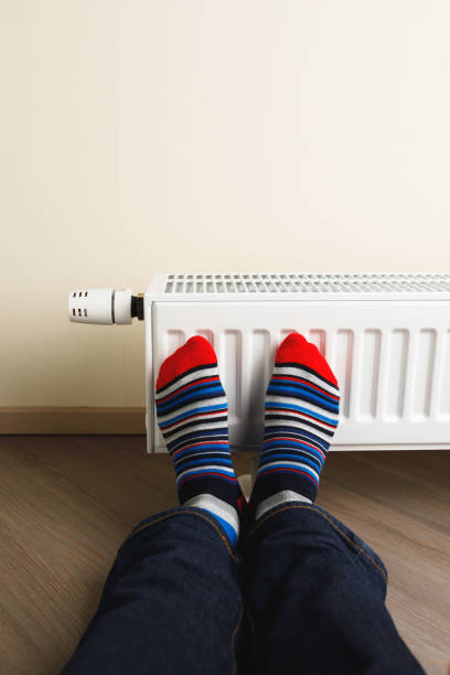 istock legs with colorful socks in front of heating radiator 1168004929