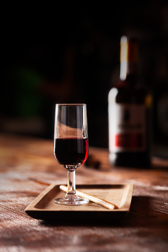 Copa de vino de Oporto sobre mesa de madera y sobre fondo oscuro photo