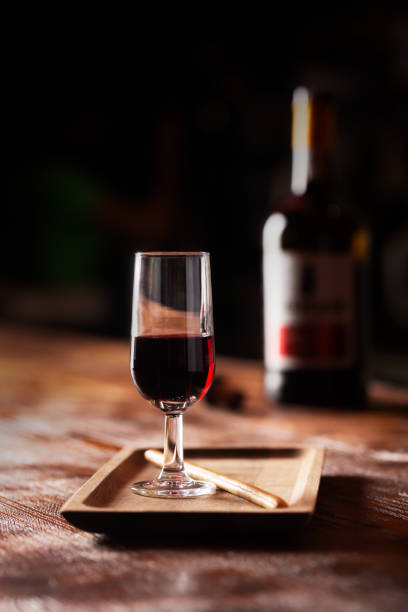 glass of port wine on wooden table and over dark background - vinho do porto imagens e fotografias de stock