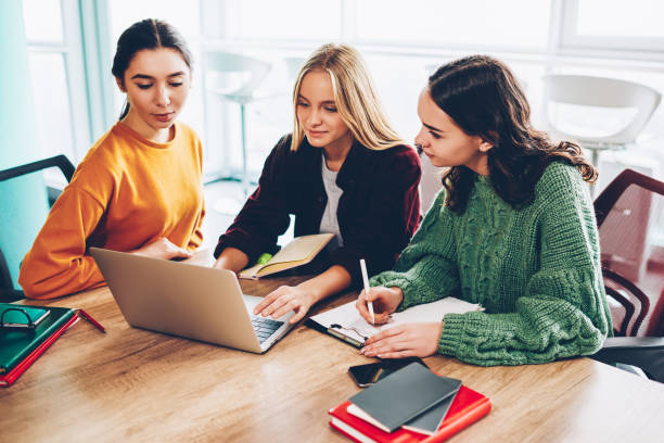 istock Pensive young women browding internet websites in search interesting information for creating new business plan working together at modern laptop computer with 4G connection in office interior 1168010585