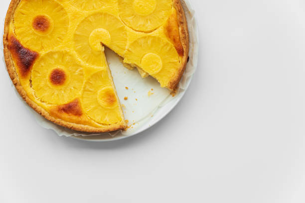 istock Sliced upside down pineapple cake on white table. Summer tropical dessert. Top view. Copy space 1168010759