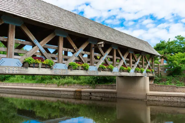 A covered wooden bridge in the Chicago suburb of Naperville Illinois along the riverwalk of the DuPage River