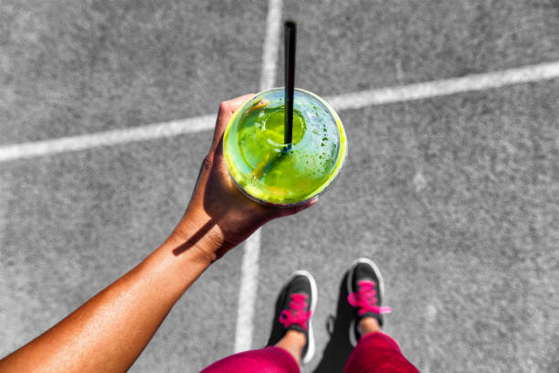 zielony koktajl działa kobieta picie filiżanki, aby przejść - juice glass healthy eating healthy lifestyle zdjęcia i obrazy z banku zdjęć