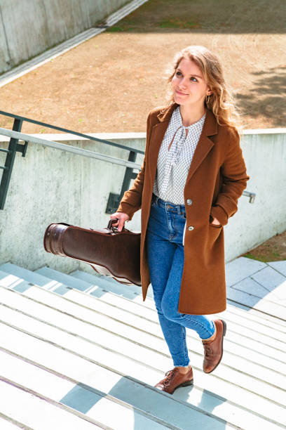 istock Blonde with violin climbs stairs and goes to class 1168014010