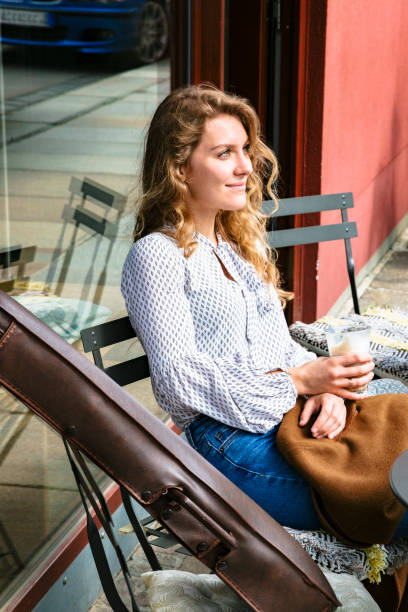 istock Young woman sitting at table in cafe with violin 1168014042