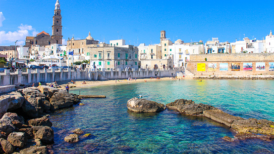 In Summer in Monopoli, little fishing village in Puglia with a fortress, tourists can relax, sunbath and swim in the beach of the old town, September 2016