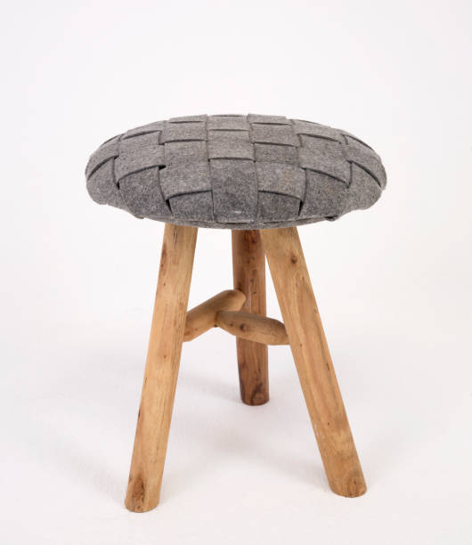 istock Old fashioned three legged wooden stool with grey cushion on white isolated background_3 1168021380