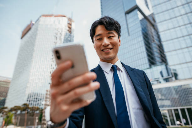 istock South Korean mature businessman in suit using mobile app 1168029552