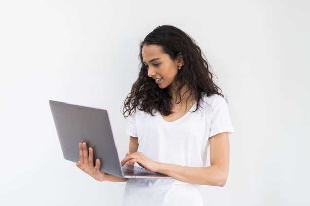 istock Thoughtful young woman using laptop on white background 1168029919