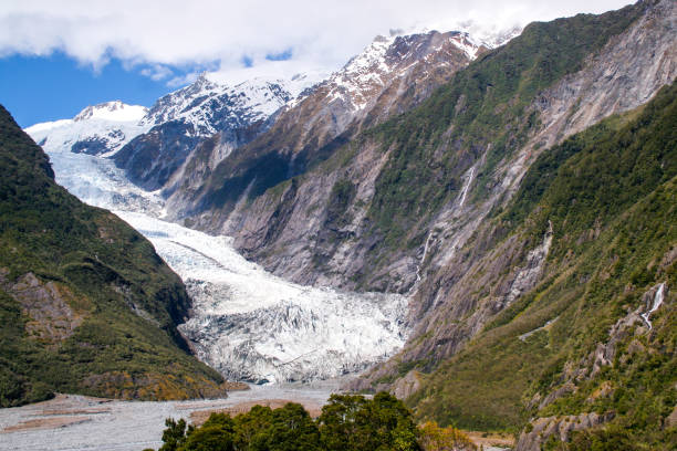 NEW ZEALAND, FOX GLACIER - MAY 2016: Hikers and travelers walking on ice in Fox Glacier, New Zealand. Breathtaking guided glacier walk onto the world-famous Fox Glacier.