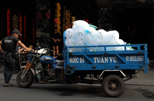 Ho Chi Minh City, Vietnam - March 28, 2019: Daily evening delivery and trade of ice in restaurants and bars on Bui Vien walking street in Saigon city. Centralized ice production.
