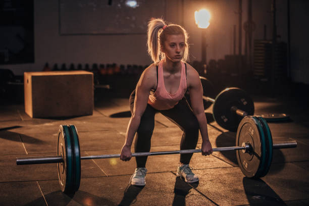istock Female bodybuilder dead lifting at the gym 1168034038