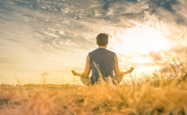 istock Young man meditating against a beautiful sunset. 1168035471