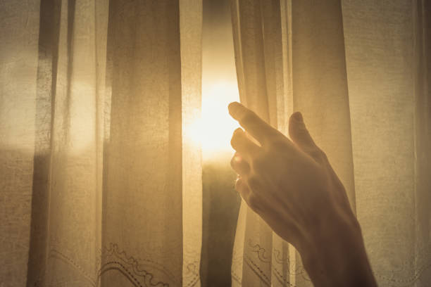 tenda della finestra che apre la mano lasciando entrare il sole del mattino presto. - curtain window women opening foto e immagini stock